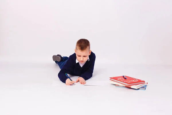 Мальчик Школьник Пишет Блокноте Белом Фоне Лежа — стоковое фото