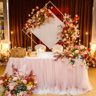 Çiçeklerle süslenmiş yeni evliler masası.