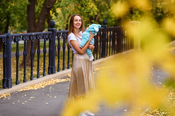 Uma Mulher Segura Bebê Macacão Quente Rua Vestido Dianteiro Folhas — Fotografia de Stock