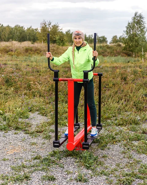 Starsza Szczupła Kobieta Pociągach Wiatrówki Symulatorach Sportowych Jesienią Świeżym Powietrzu — Zdjęcie stockowe