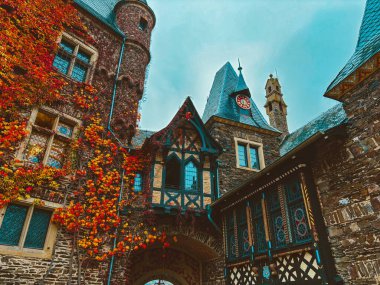 Sonbaharda mavi gökyüzüne karşı Cochem kasabasında bir dağ yamacında bir ortaçağ şatosu