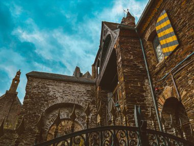 Sonbaharda mavi gökyüzüne karşı Cochem kasabasında bir dağ yamacında bir ortaçağ şatosu