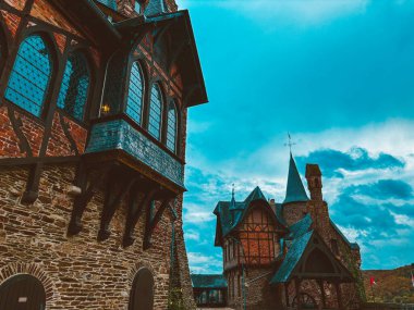 Sonbaharda mavi gökyüzüne karşı Cochem kasabasında bir dağ yamacında bir ortaçağ şatosu