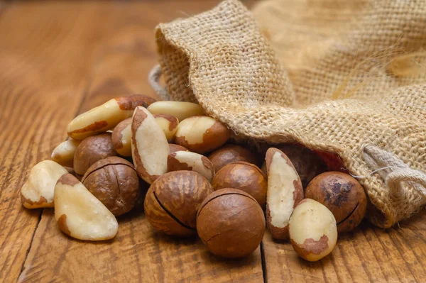 Brazil nut grains and macadamia nuts on a board close up