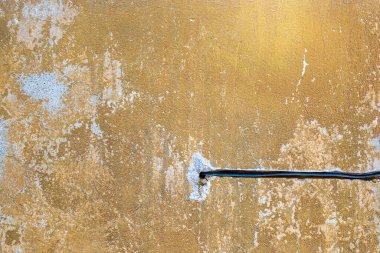 Havalı duvar ve elektrik kablosu arka planda. Gri çatlamış kahverengi ve gri doku