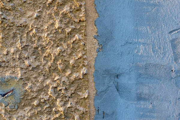시멘트 질감은 수직으로 파란색으로 나뉘고 울퉁불퉁 표면과 베이지 부분으로 나뉘어 — 스톡 사진