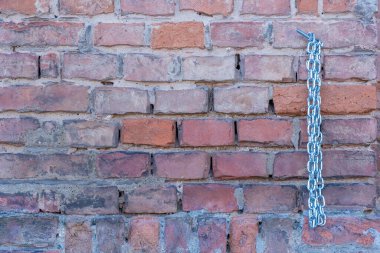 Yeni, parlak bir zinciri olan tuğla bir duvar. İlginç bir kombinasyon