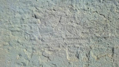 Kaba, açık renkli taş ya da betondan ince tonlama ve desen değişiklikleriyle dokulu bir yüzey.