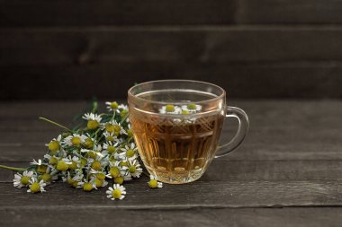 Ahşap arka planda papatya çayı..