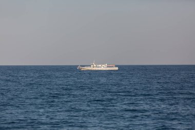 Beyaz bir tekne denizde yelken açıyor. Ufuk çizgisi.