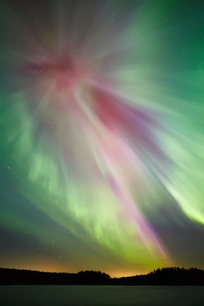 Northern lights and  green aurora corona in the cold winter sky.