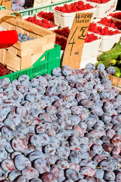 Ciruelas y bayas para la venta en un mercado — Foto de Stock