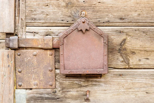 Старая ржавая металлическая защелка на деревянных дверях — стоковое фото