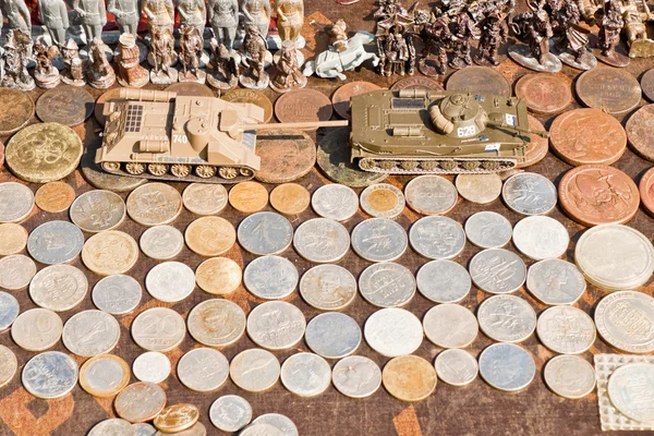 Münzen, Spielzeugsoldaten und Panzer zum Verkauf auf einem Flohmarkt — Stockfoto