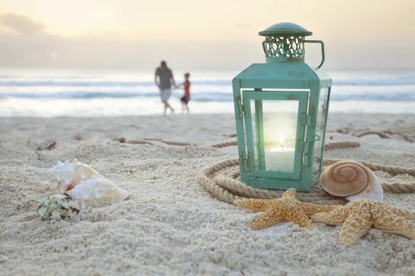 Windlicht met schelpen op het strand en de vader en zoon colle soft focus Sea... — Stockfoto