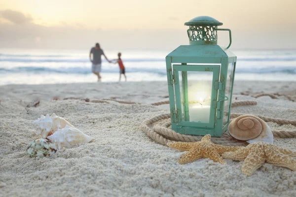 Lantern with shells on beach and soft focus father and son colle — Stock Photo, Image