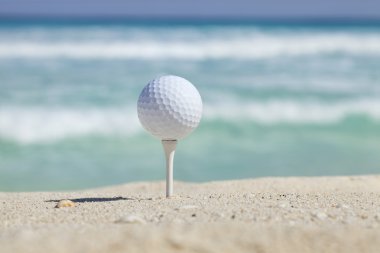 Kum Beach ile okyanus dalgaları arkasında tee Golf topu