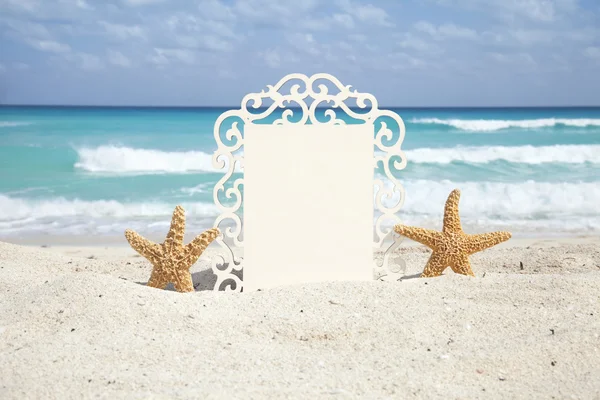 Starfish houden een fancy frame op oceaan strand — Stockfoto