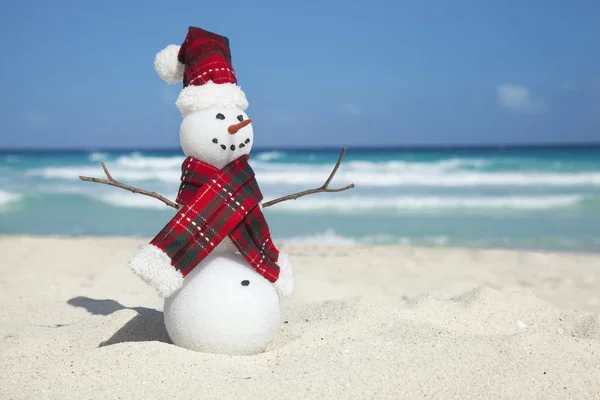 Миниатюрный снеговик и шарф на пляже — стоковое фото