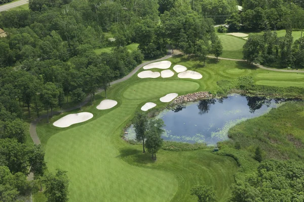 Vista aérea del campo de golf y verde con trampas, estanque y árboles —  Fotos de Stock
