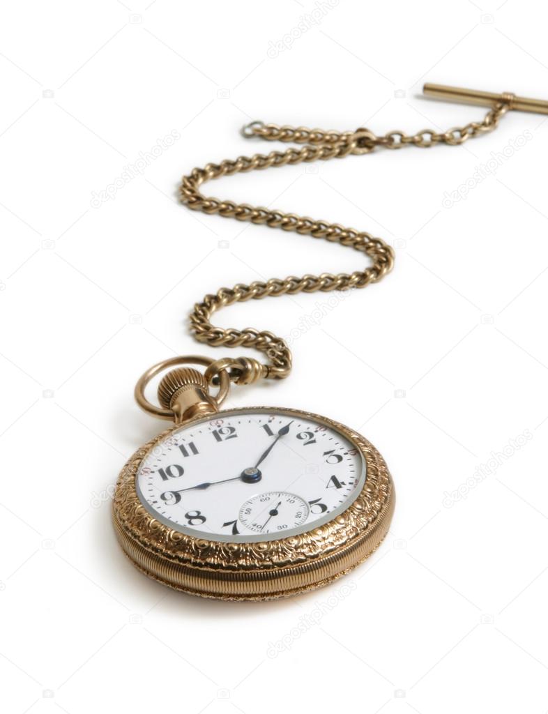 Vintage gold watch with chain lying on white background