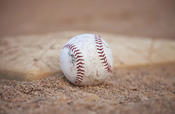 Selective focus low angle of grungy baseball and base — Stock Photo, Image