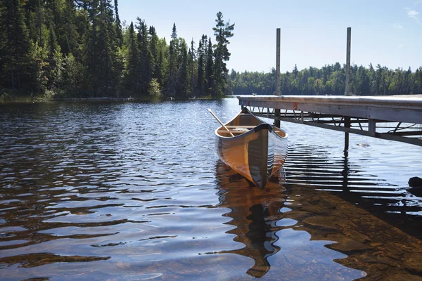 Canoa amarrada a uma doca em um lago no norte de Minnesota — Fotografia de Stock