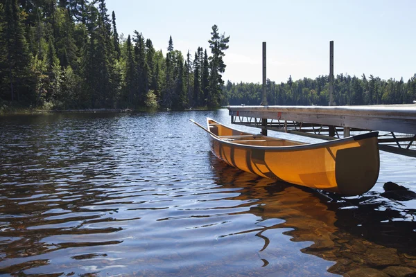 Canoe tied to a dock on a northern Minnesota lake — Stock Photo, Image