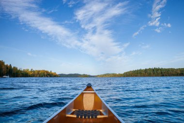 Parlak bir sonbahar gününde, kuzey Minnesota gölünde, ultra hafif sarı bir kano.
