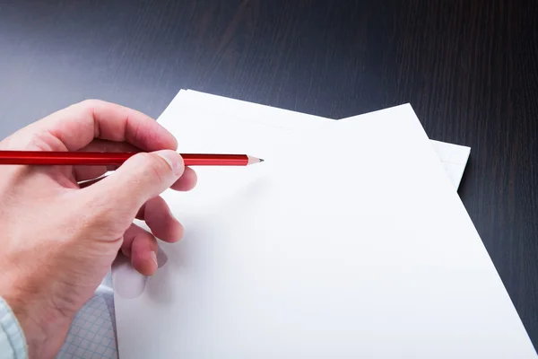 El hombre toma notas a lápiz sobre papel . — Foto de Stock