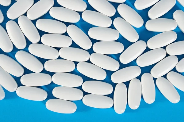 Bovenaanzicht van witte pillen op een blauw — Stockfoto