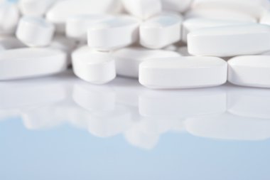 Yığın beyaz hap mavi bir yakın çekim