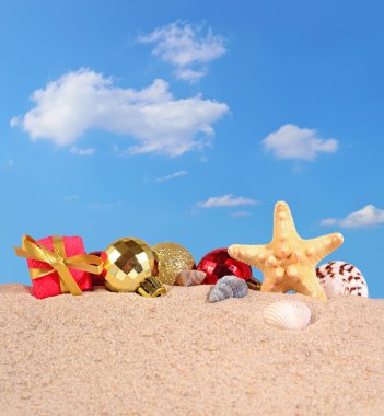 Noel süsleri, kabukları ve denizyıldızı plaj kum üzerinde