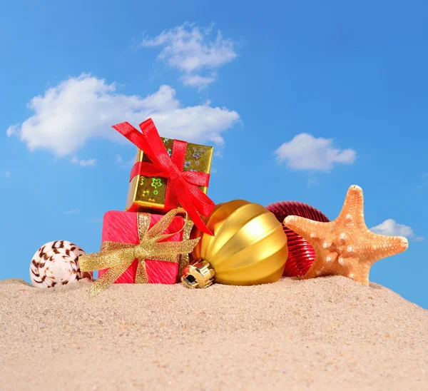 Noel süsleri, kabukları ve denizyıldızı plaj kum üzerinde