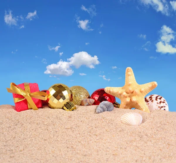 Decoraciones navideñas, conchas marinas y estrellas de mar en una playa de arena — Foto de Stock