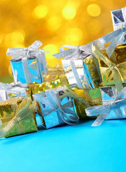 Golden and silver gifts on a colorful bokeh background — Stock Photo, Image