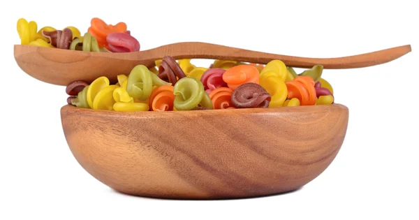 Colored italian pasta in a wooden bowl on a white — Stock Photo, Image