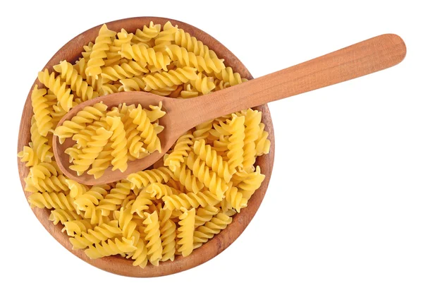 Uncooked italian pasta fusilli in a wooden bowl on a white — Stock Photo, Image