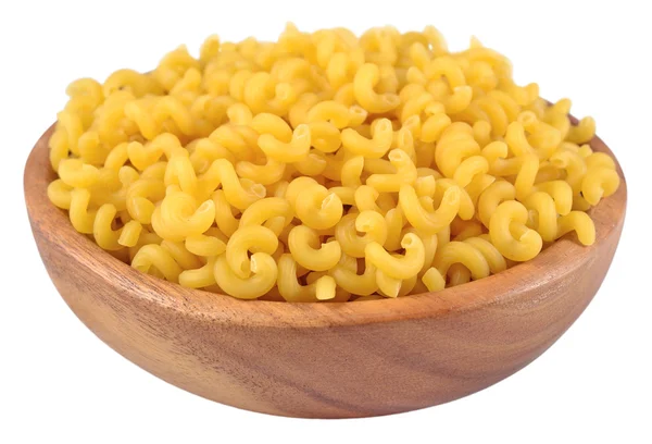 Uncooked italian pasta in a wooden bowl on a white — Stock Photo, Image