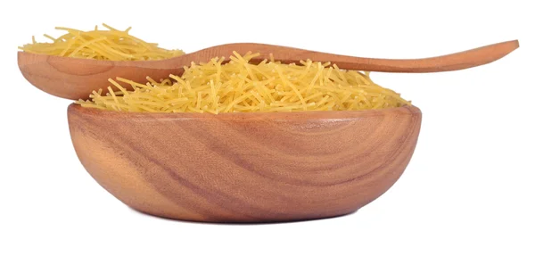 Uncooked italian pasta in a wooden bowl on a white — Stock Photo, Image