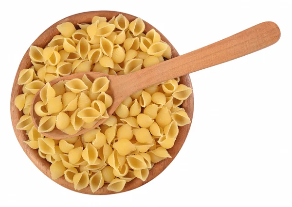 Conchas de pasta italiana sin cocer en un tazón de madera sobre un blanco —  Fotos de Stock