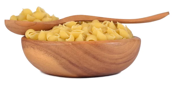 Uncooked italian pasta shells in a wooden bowl on a white — Stock Photo, Image