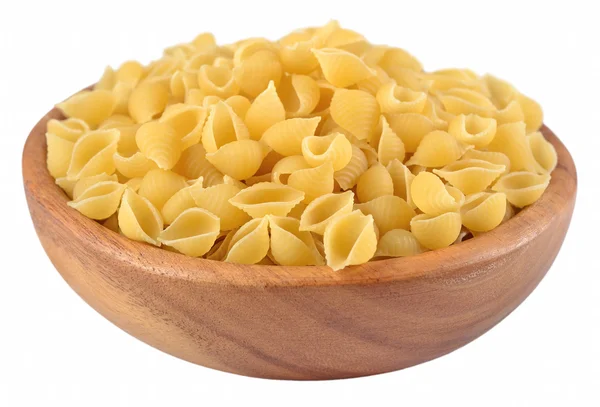 未煮熟的意大利面食壳在一个木碗在一张白纸 — 图库照片