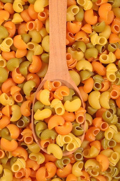 Tubo di pasta italiana cruda colorato rigare in un cucchiaio — Foto Stock