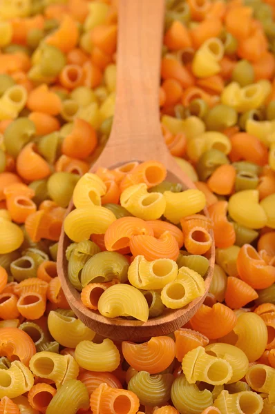 Tubo di pasta italiana cruda colorato rigare in un cucchiaio — Foto Stock