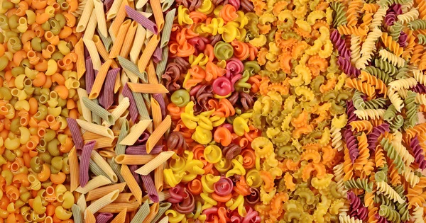 Assortment of colored uncooked Italian pasta as background — Stock Photo, Image