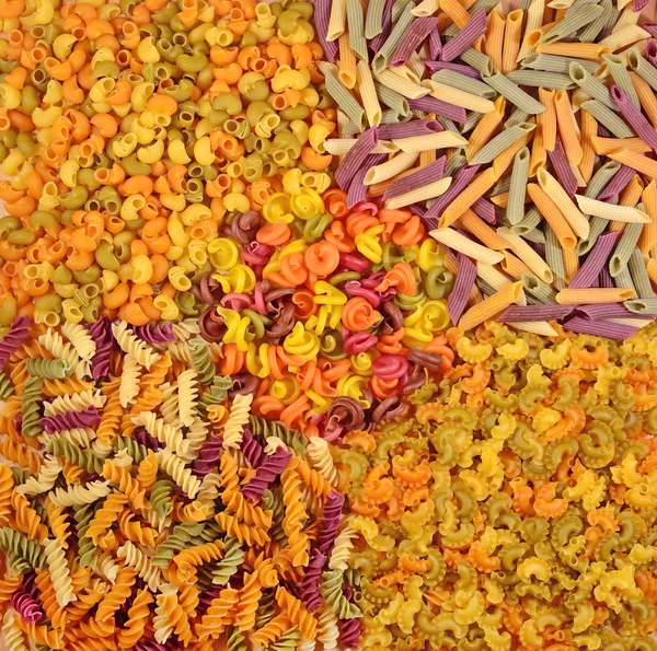 Assortment of colored uncooked Italian pasta as background — Stock Photo, Image