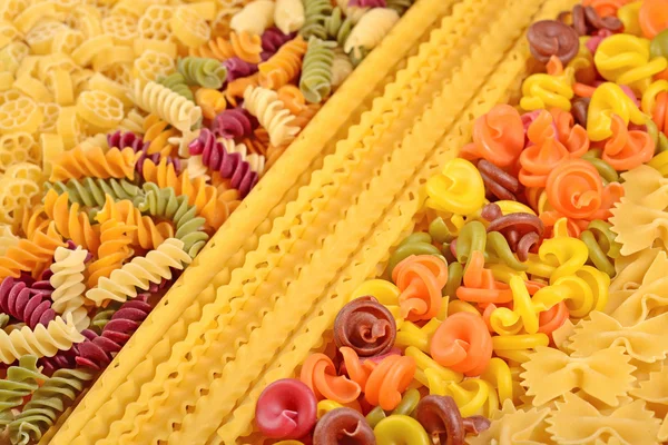 Assortment of colored uncooked Italian pasta close up — Stock Photo, Image