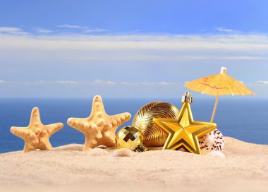 Noel süslemeleri kabukları ve denizyıldızı plaj kum üzerinde 