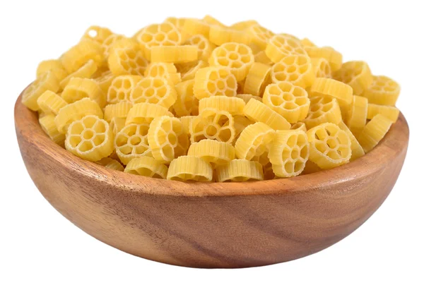 Uncooked italian pasta rotelle in a wooden bowl on a white — Stock Photo, Image